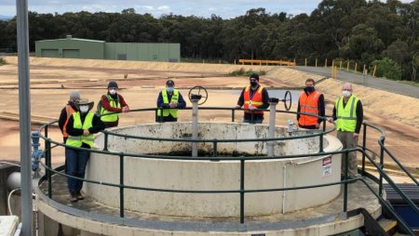 Team members stand around infrastructure at the Moe Water Treatment Plant