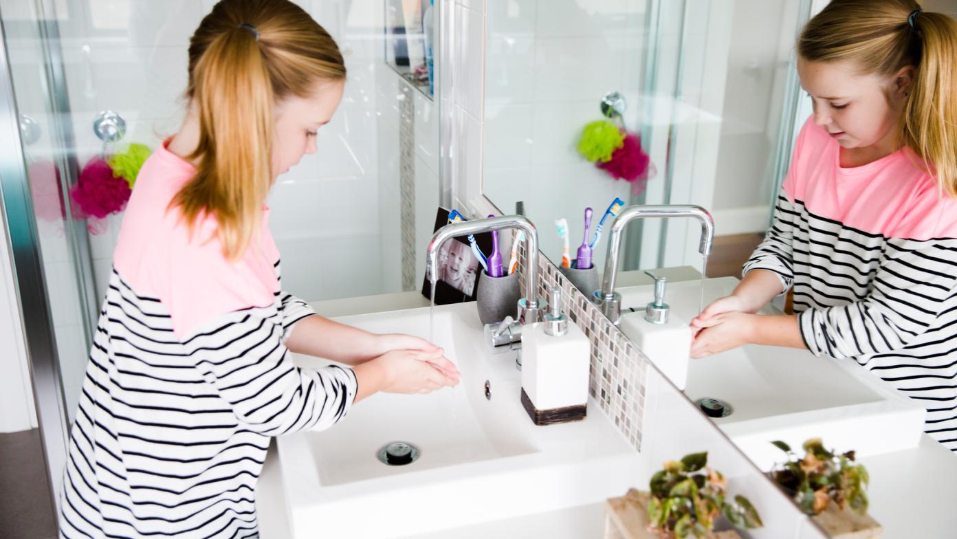 A girl washing her hands in the bathroom