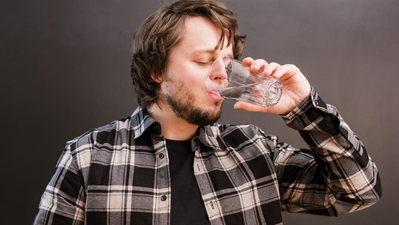 Man drinking a glass of water.