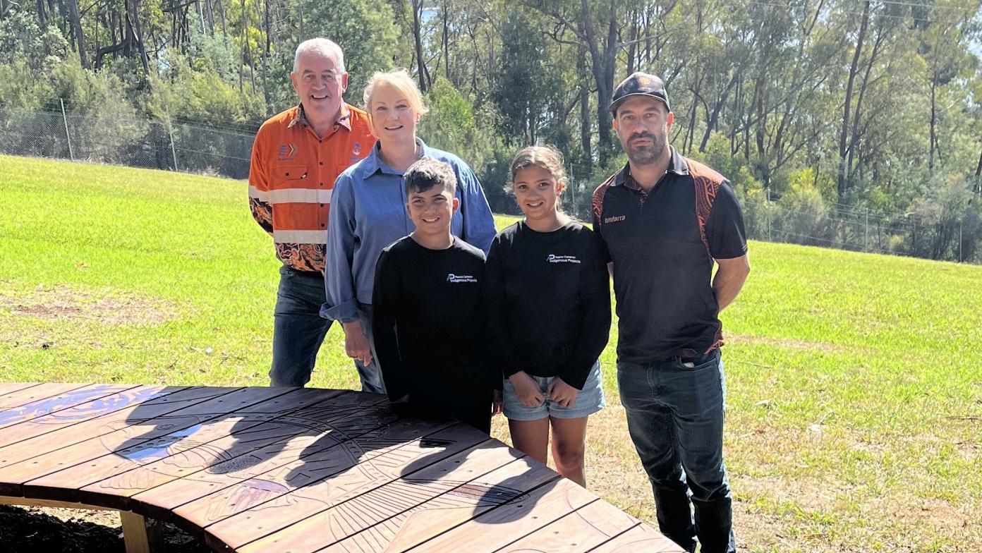 Gippsland Water representatives standing in front of boomerang shaped wooden viewing platform