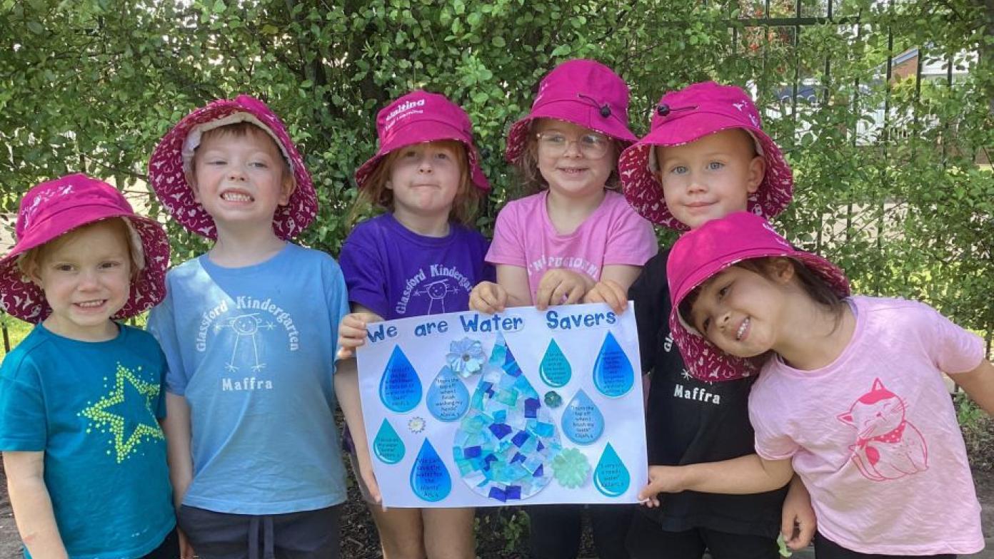 Kinder kids proudly holding their prize.
