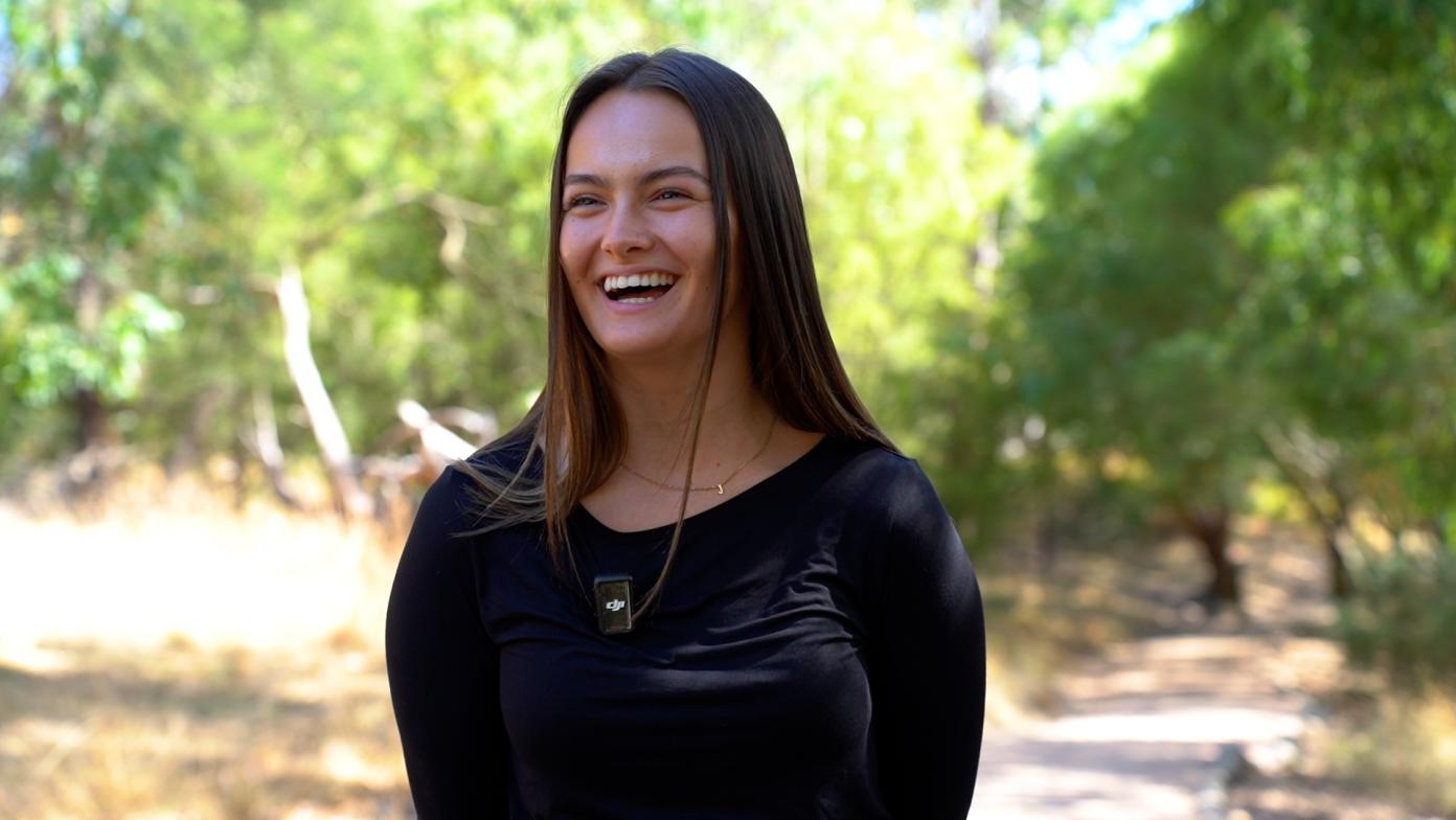 a women laughing on a green nature trail