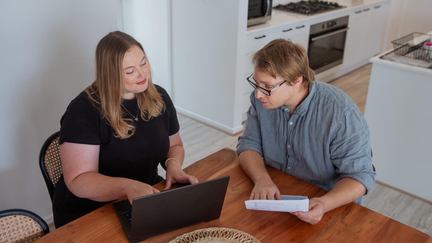 Two people looking at a laptop screen.