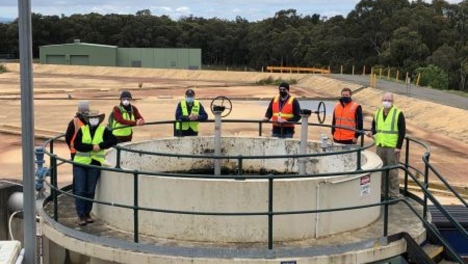 Team members stand around infrastructure at the Moe Water Treatment Plant
