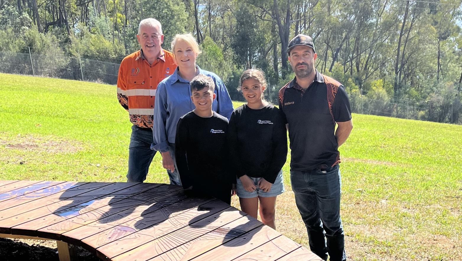 Gippsland Water representatives standing in front of boomerang shaped wooden viewing platform