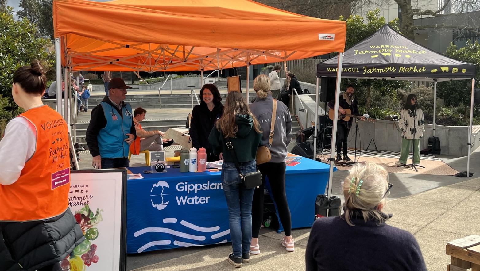 Gippsland Water staff speaking with community members at the Warragul Farmers Market in 2024.