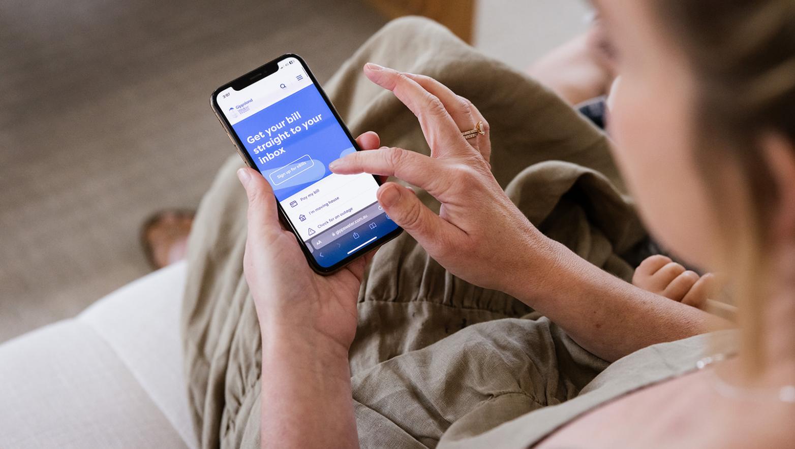 Woman reads Gippsland Water website on her phone