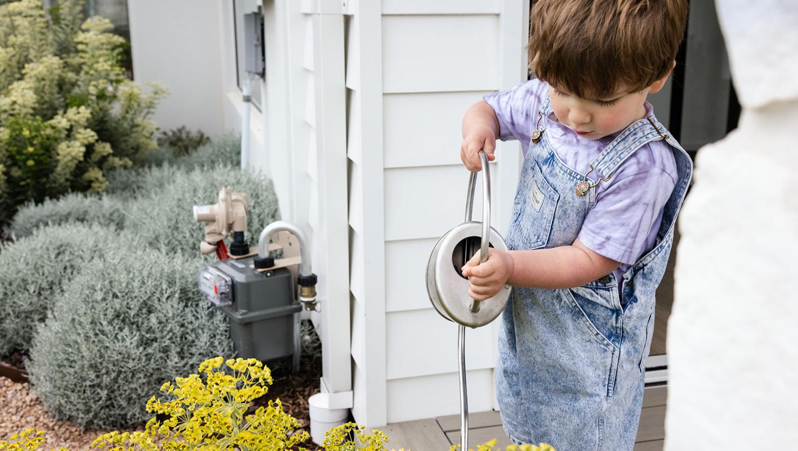 Child watering the garden with a watering can
