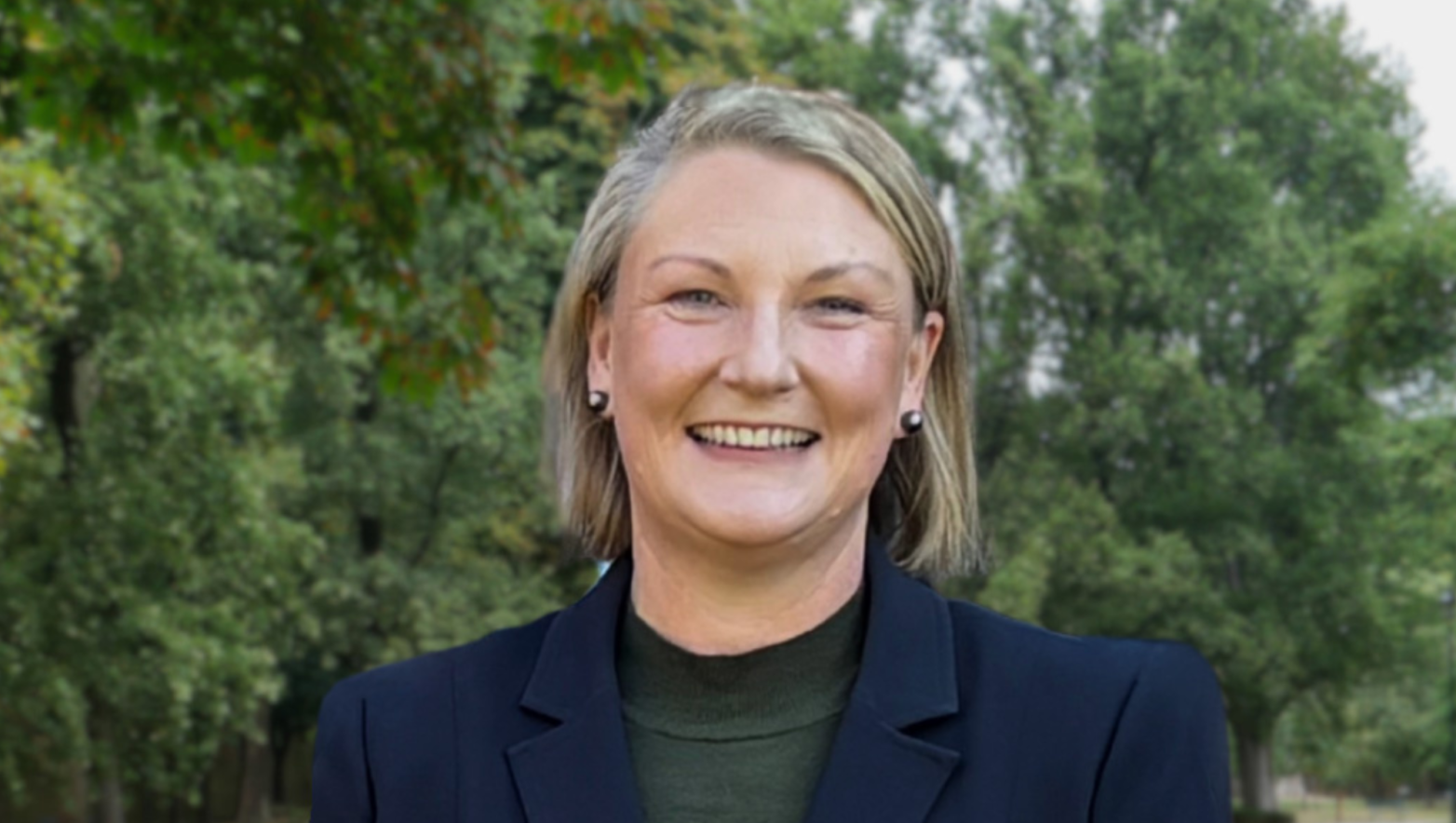 Professional headshot of Sarah Cumming standing at a park