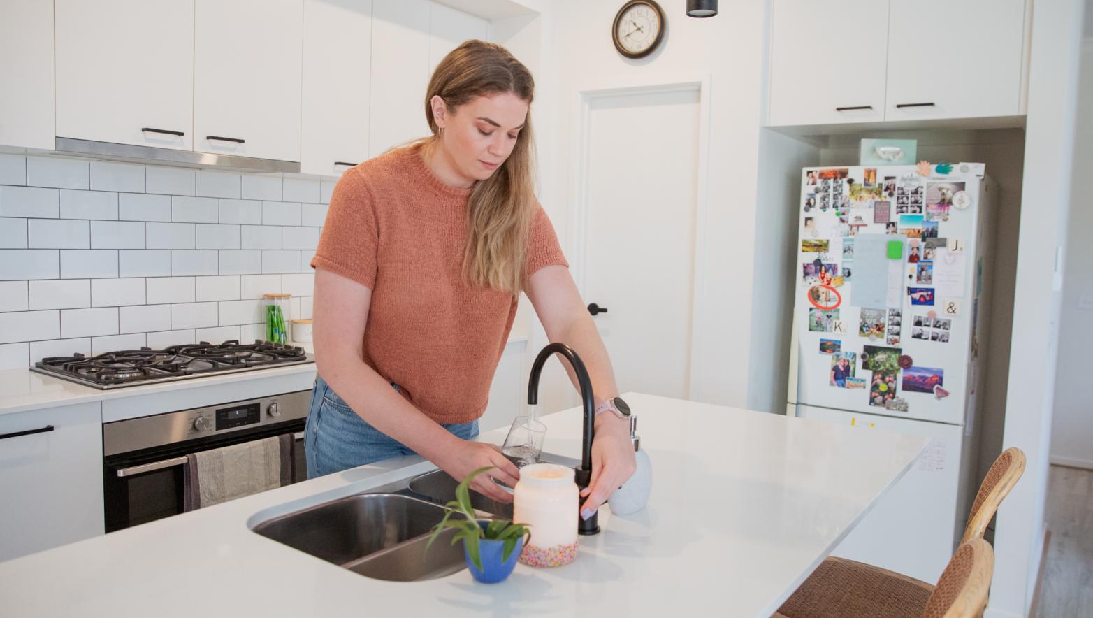Woman filling cup with tap water
